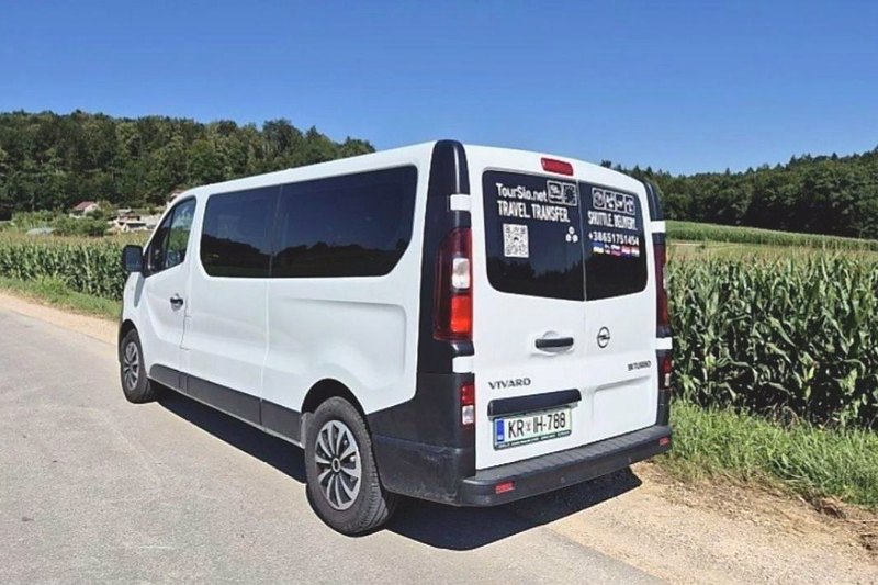 Белый Opel Vivaro сзади, на стекле надпись TourSlo.net Travel Transfer