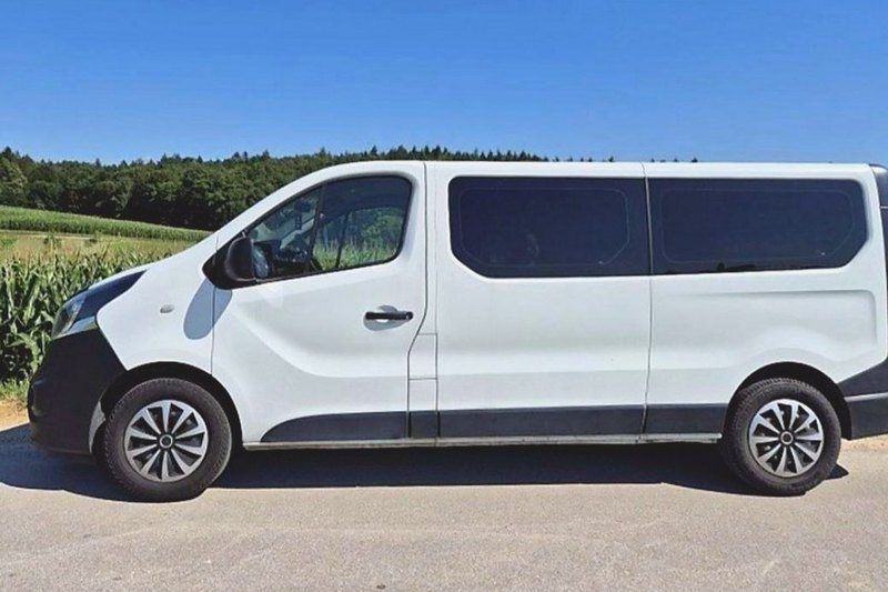 Белый Opel Vivaro сбоку на дороге у кукурузного поля
